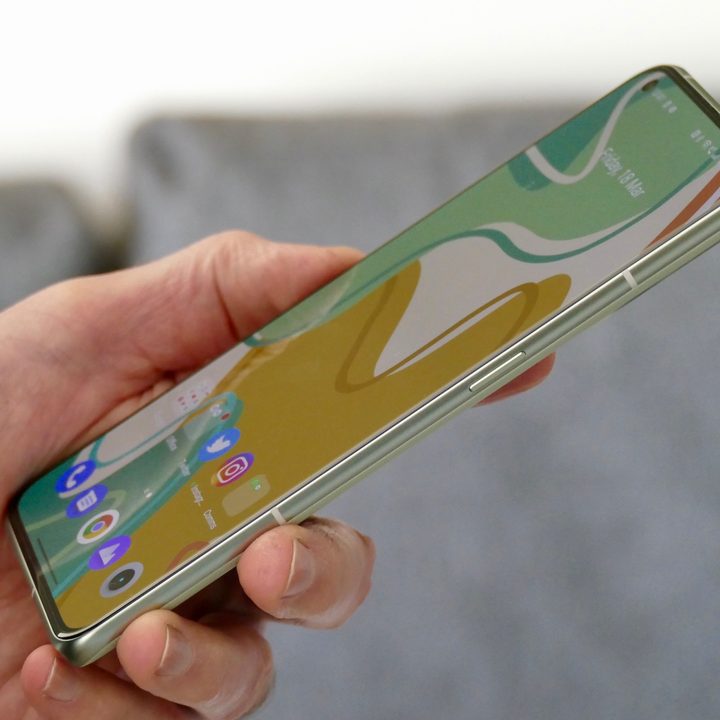 The Realme GT 2 Pro seen from the side while held in one hand.