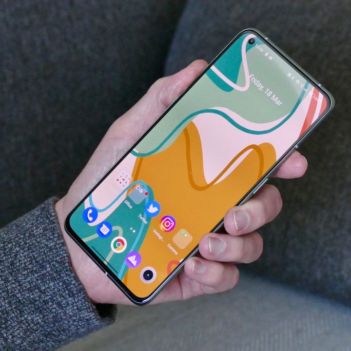 A hand holds the Realme GT 2 Pro with the screen visible.