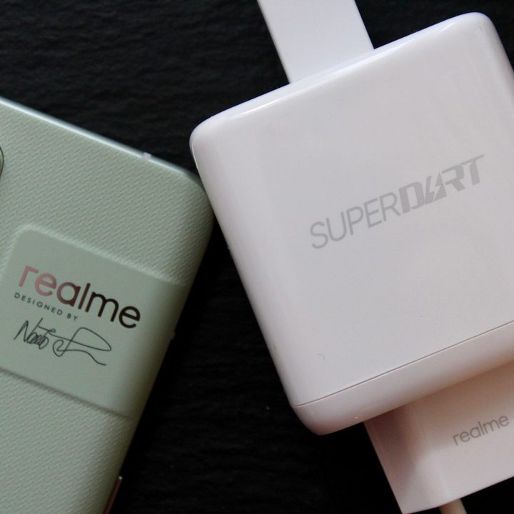 Realme's SuperDart charging block next to a Realme phone.