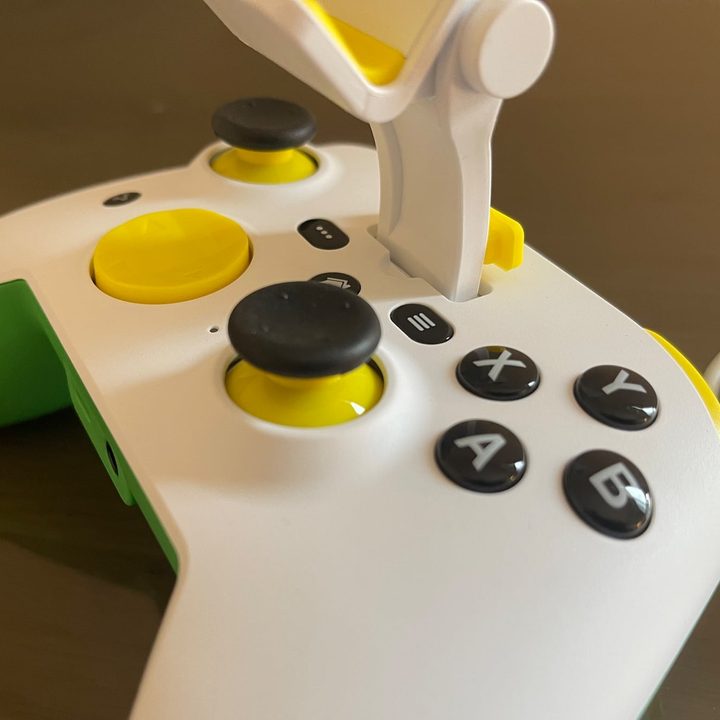 A close-up of RiotPWR ESL iPhone game controller with the iPhone mount inserted.