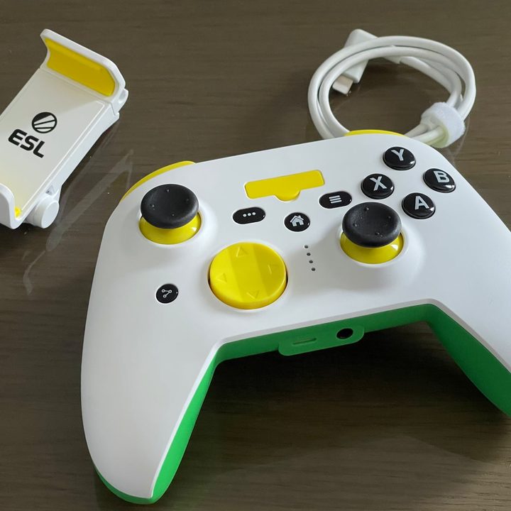 The RiotPWR ESL Game Controller with coiled Lightning cable and iPhone mount on a table.