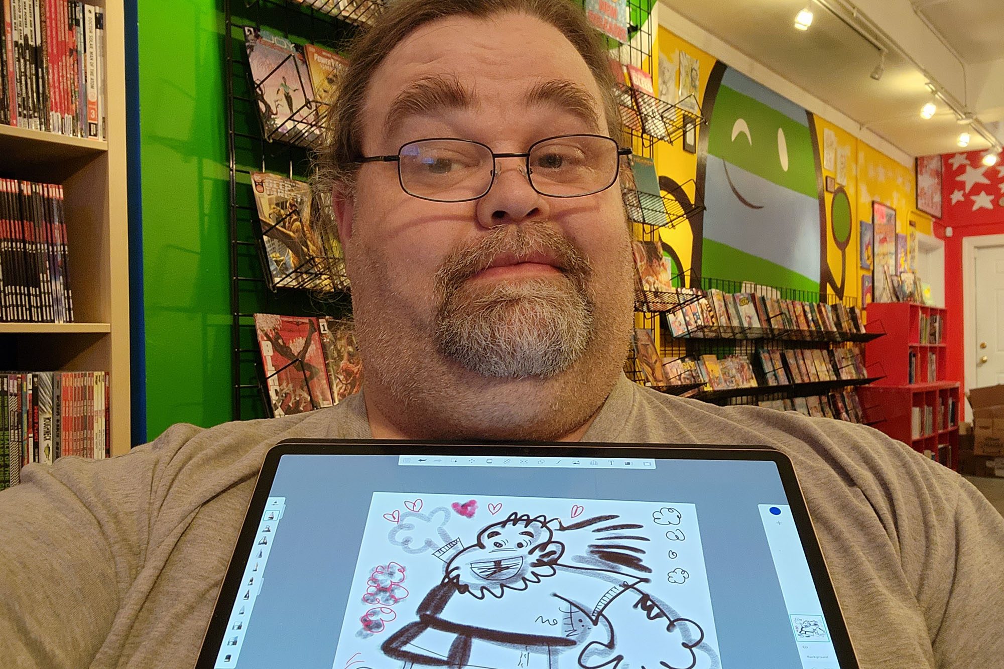 Adam hold up the sketch in a selfie.