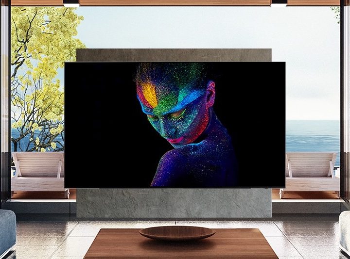 A 2022 Samsung OLED TV S95B seen wall-mounted in front of a large window.