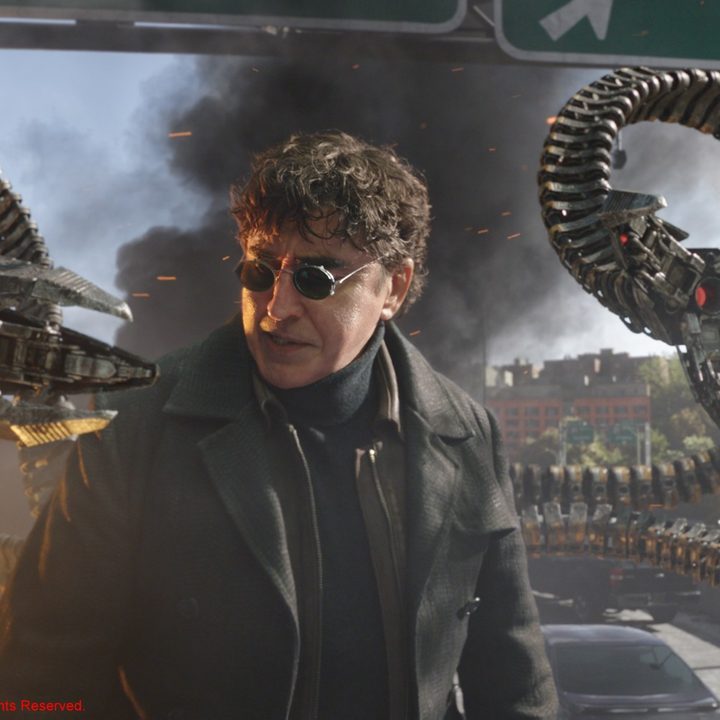 Alfred Molina stands amid destruction on a bridge in a scene from Spider-Man: No Way Home.