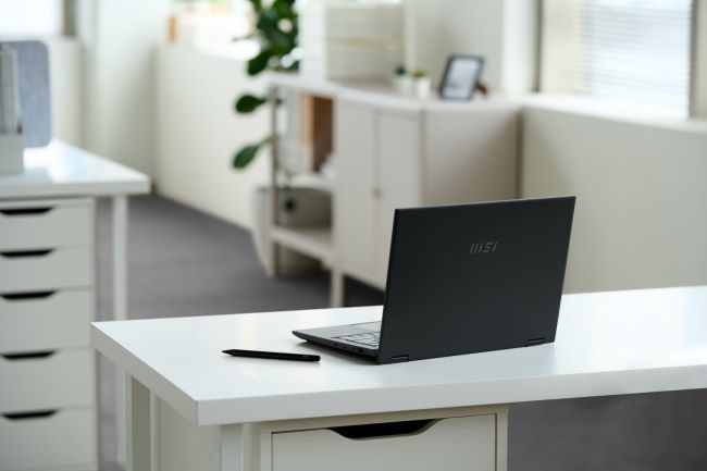 The MSI Summit E14 Flip Evo on a desk in an office.