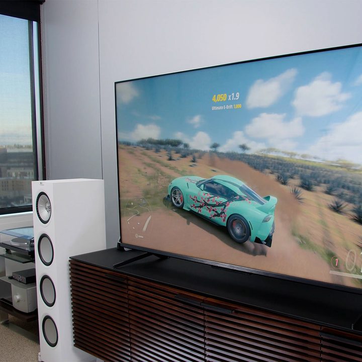 Angled TCL TV with a video game being played on screen.