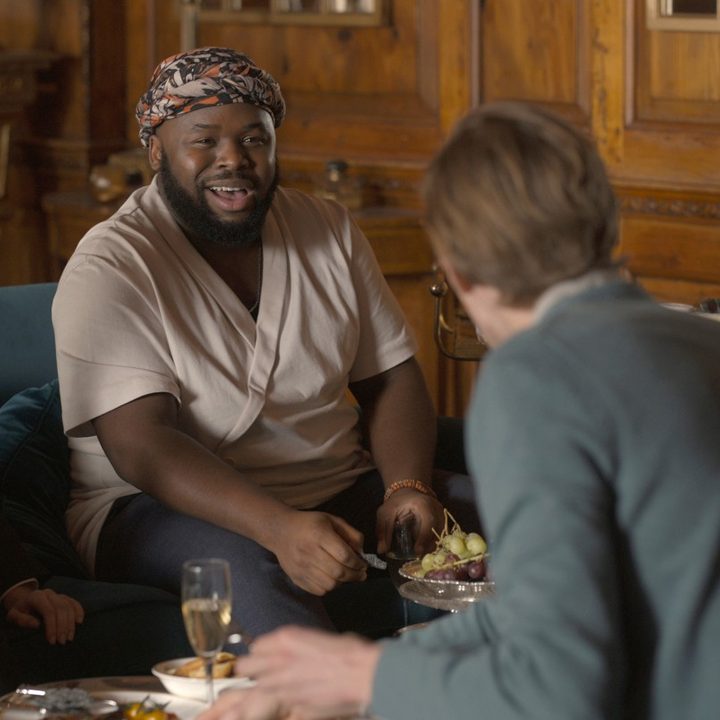 Maria Bakalova, Samson Kayo, Harry Trevaldwyn, and Vir Das laugh on a couch in a scene from The Bubble.