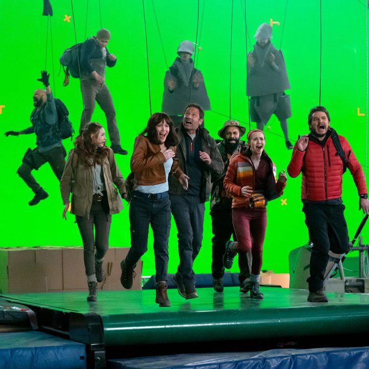 The cast of The Bubble pretends to run against a green-screen backdrop in a scene from the film.