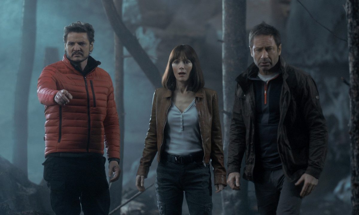 Pedro Pascal, Leslie Mann, and David Duchovny stare into a forest in a scene from The Bubble.