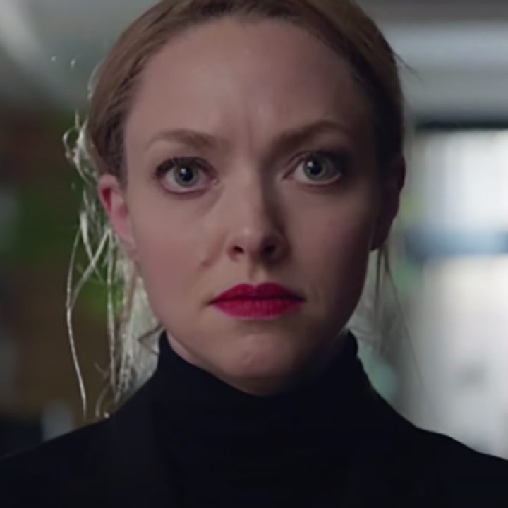 Elizabeth Holmes staring into the camera, wearing a black turtleneck as Elizabeth Holmes in The Dropout.