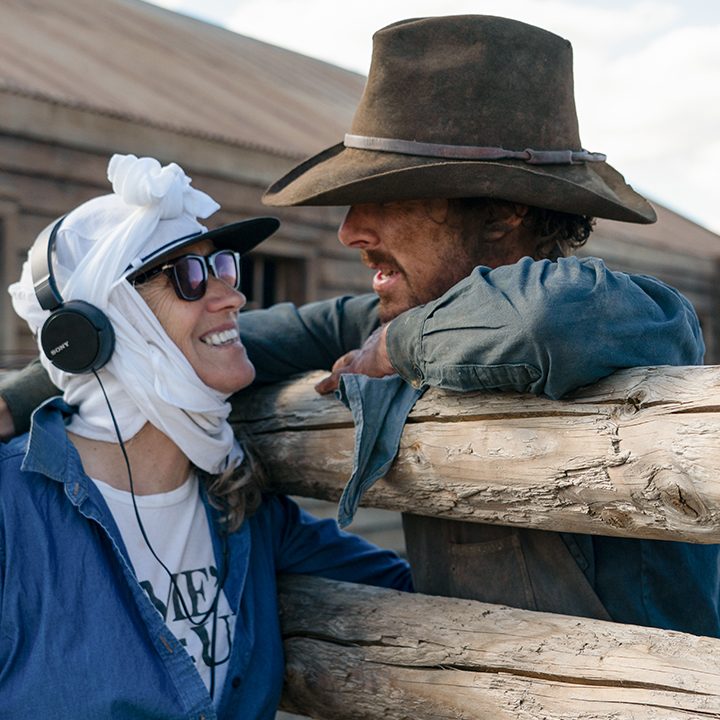 Jane Campion with a white sheet around her head talking to Benedict Cumberbatch behind-the-scenes of The Power of the Dog.