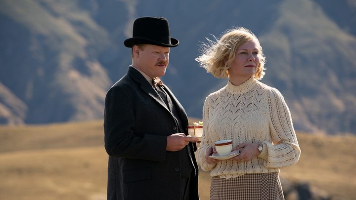 Jesse Plemon and Kirsten Dunst standing together holding coffee cups in a scene from The Power of the Dog.