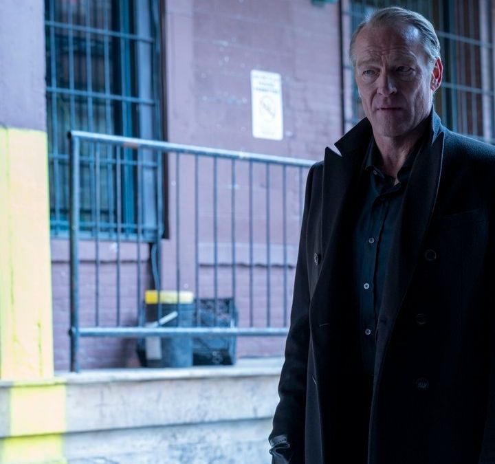 Iain Glen as Bruce Wayne standing on an empty street in Titans.