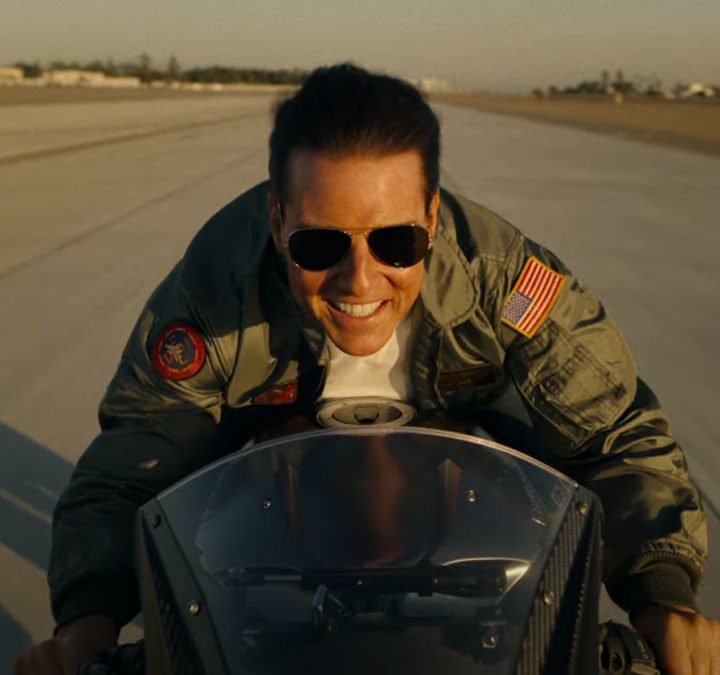 Tom Cruise rides a motorcycle in Top Gun: Maverick.