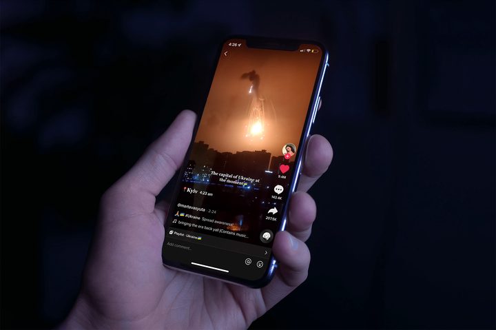 Person holding an iPhone as it plays a TikTok of the a bombing in Ukraine.