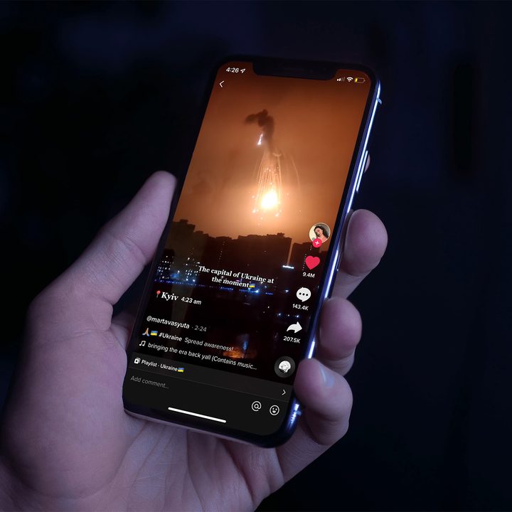 Person holding an iPhone as it plays a TikTok of the a bombing in Ukraine.