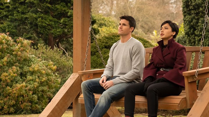 Nathan and Nora sitting on a bench together in Lakeview on "Upload."