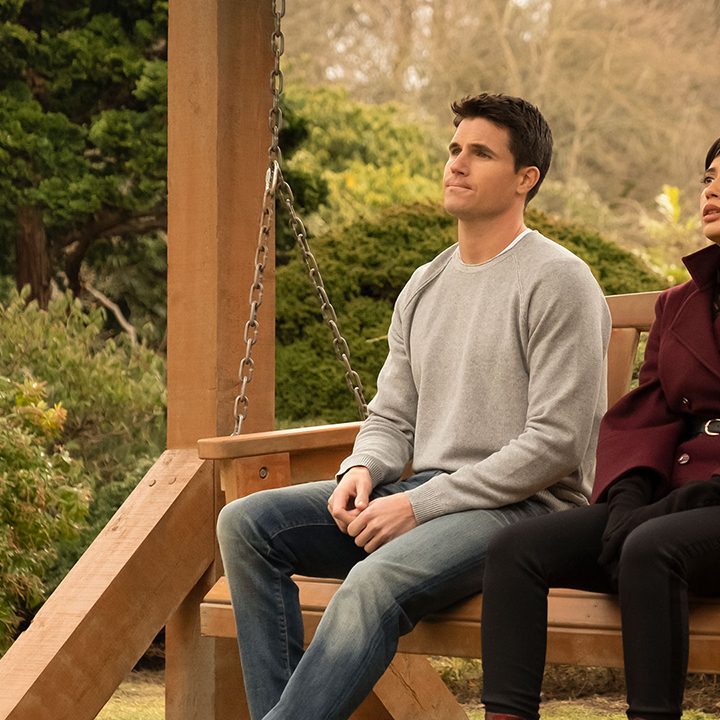 Nathan and Nora sitt on a bench together in Lakeview on the Amazon Prime show Upload.