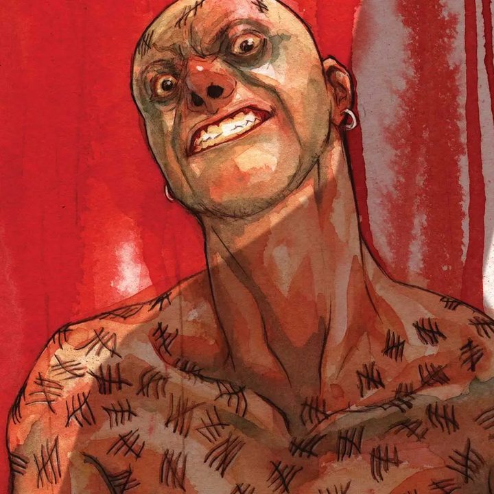 Victor Zsasz covered in scars on a bloody background in the Batman comics.