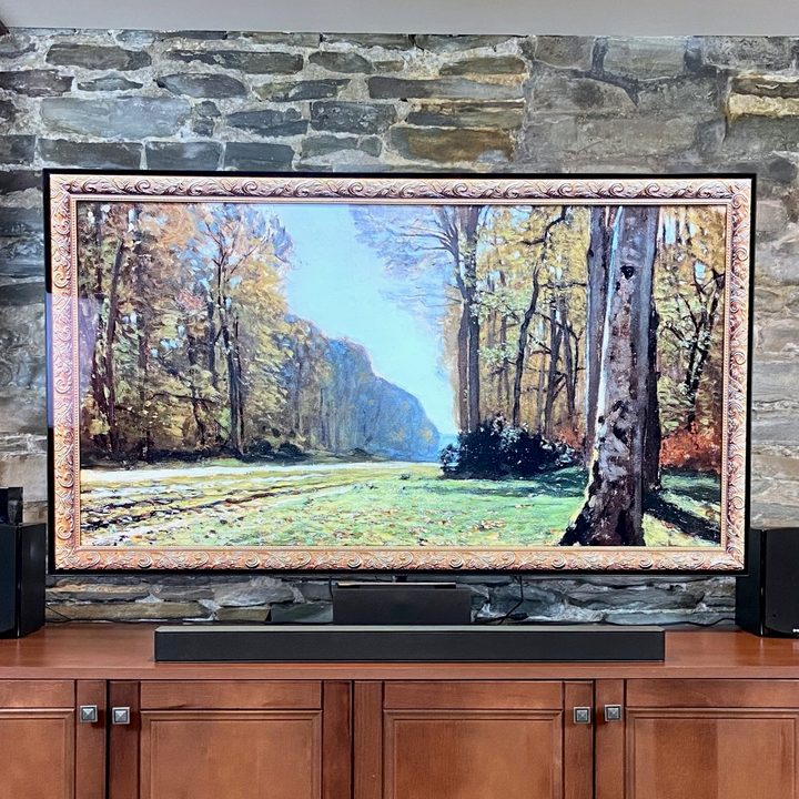 Vizio M-Series 2.1 soundbar sits beneath with a 65-inch TV displaying a work of art featuring trees.