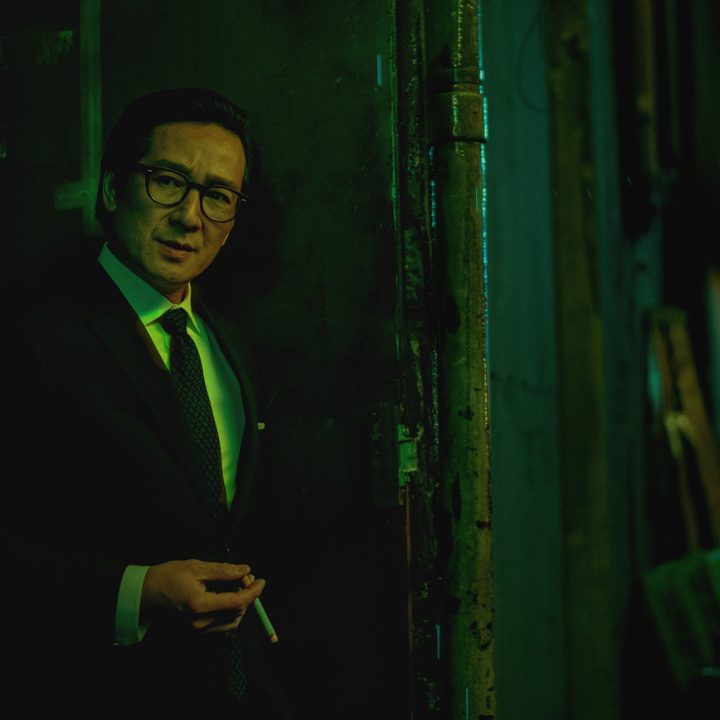 Ke Huy Quan stands in an alley in Everything Everywhere All At Once.
