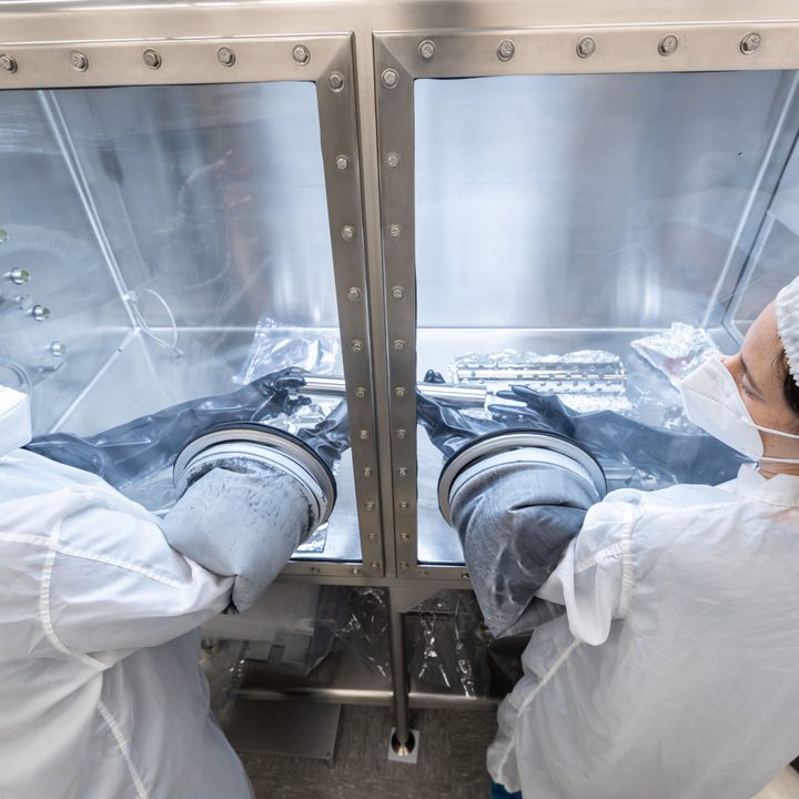 Researchers from the Astromaterials Research and Exploration Science Division (ARES) group careful handle a sample tube containing a lunar sample at NASA’s Johnson Space Center in Houston.