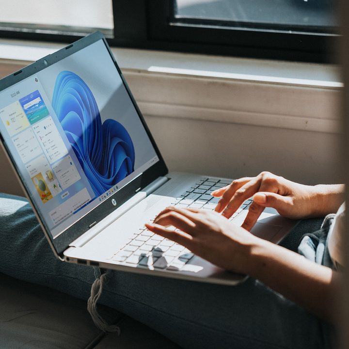 Person sitting and using an HP computer with Windows 11.