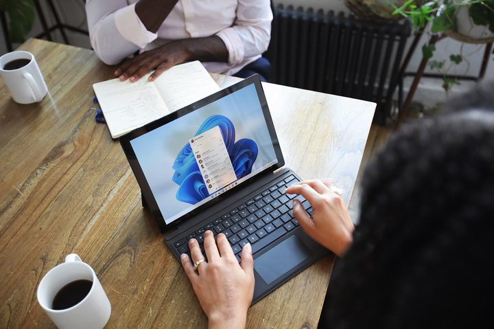 Person sitting and using a Windows Surface computer with Windows 11.