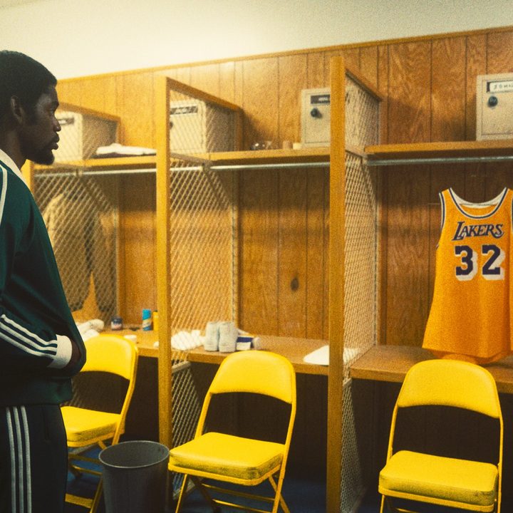 Quincy Isaiah as Earvin "Magic" Johnson stares at a jersey in a locker in HBO's Winning Time series.