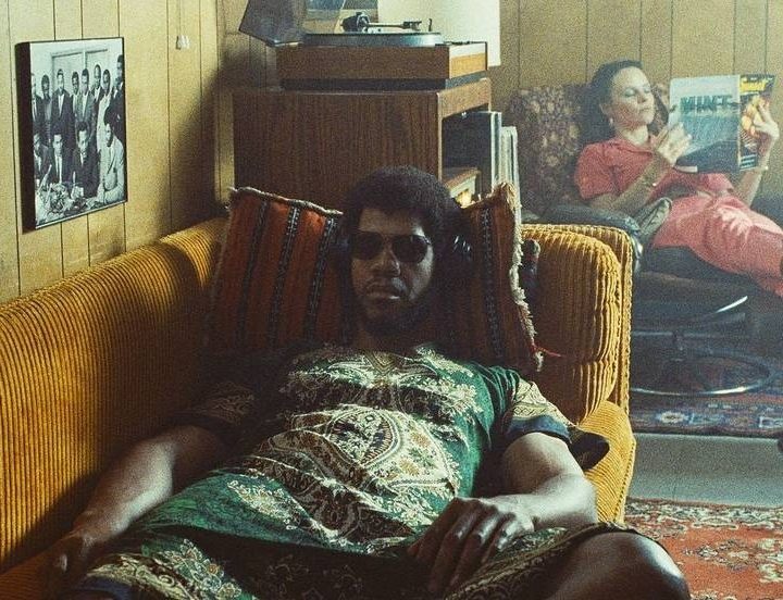 Solomon Hughes as Kareem Abdul-Jabbar rests on a couch in a scene from HBO's Winning Time.