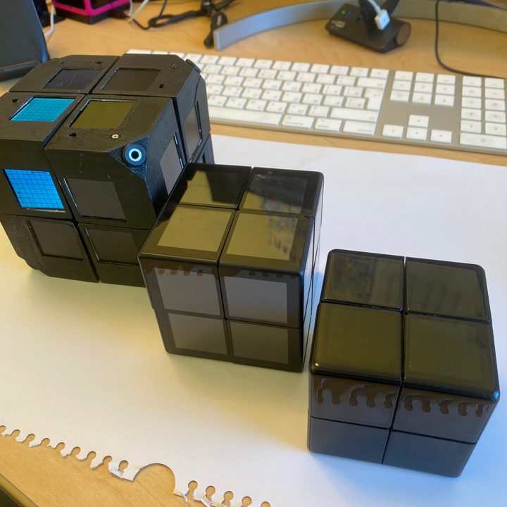 Three Wowcube prototypes sit on a desk.