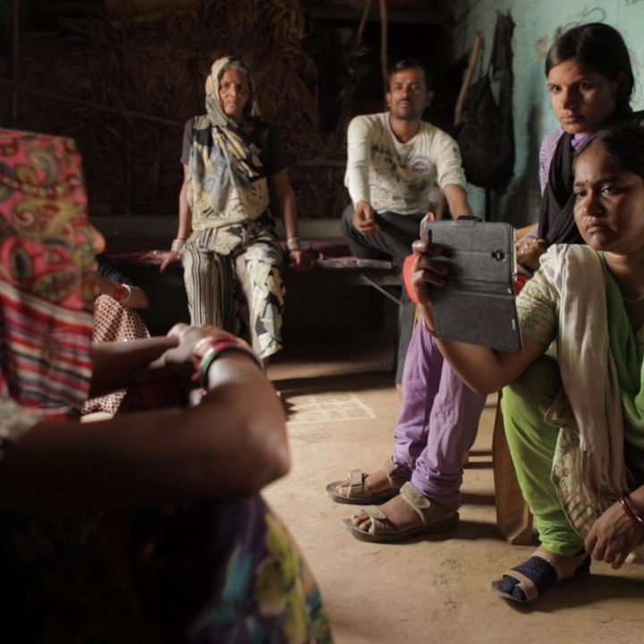 A woman records an interview with an iPhone in a scene from Writing With Fire.