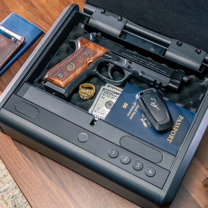 An open Wyze Gun Safe with a hand gun, passport, and other items inside.