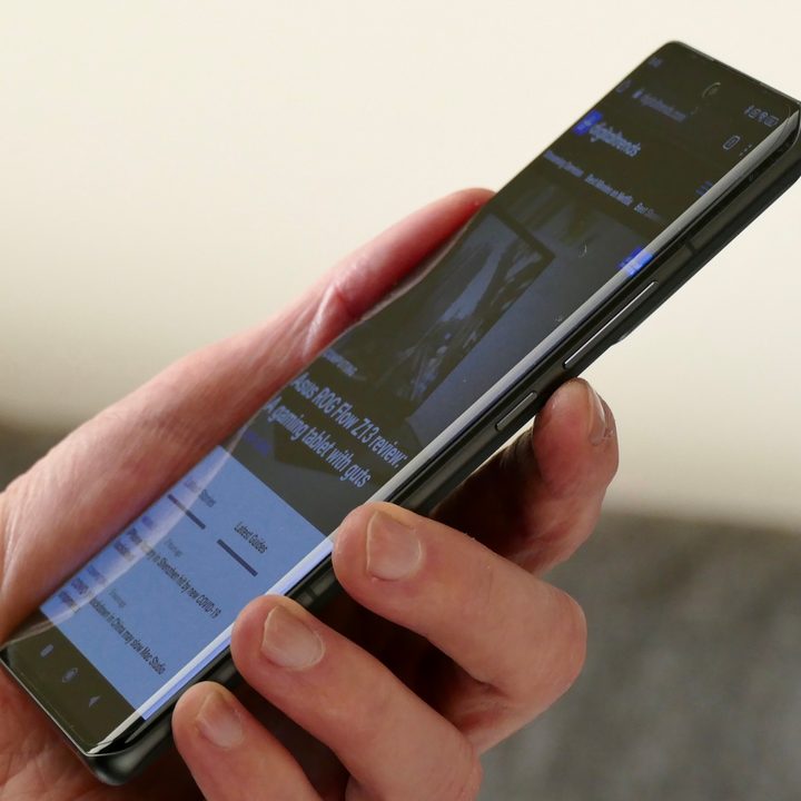 A hand holds the Xiaomi 12 Pro, with the Digital Trends homepage visible.