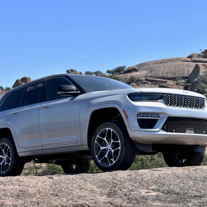 The 2022 Jeep Grand Cherokee 4xe plug-in hybrid perched on a rock.