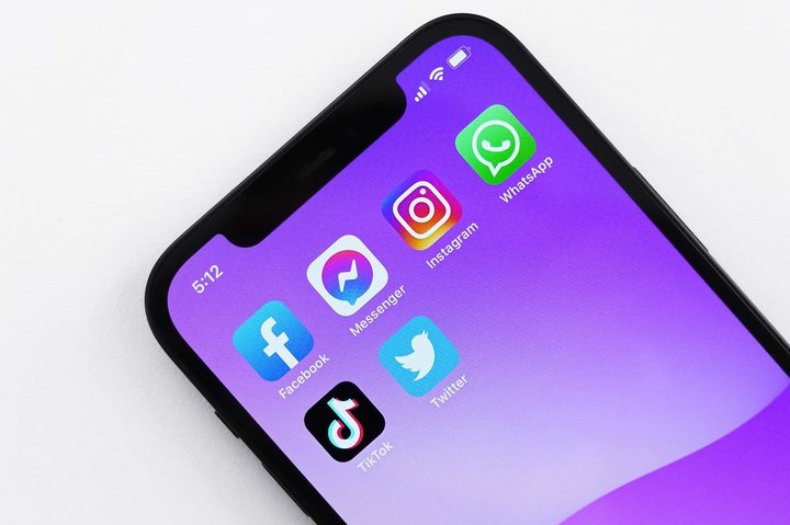 A series of social media app icons on a colorful smartphone screen.