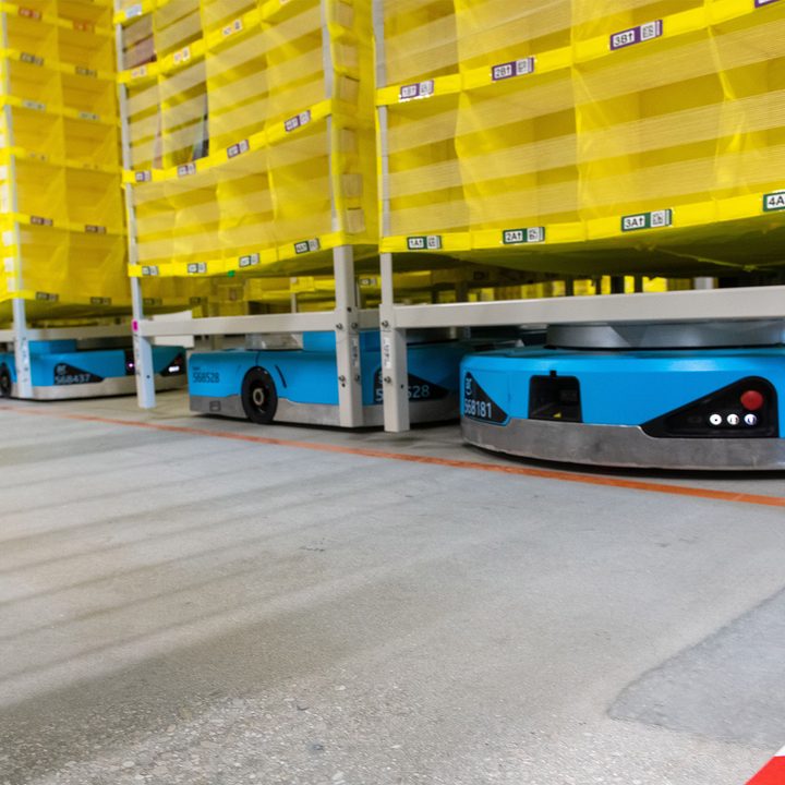 Amazon logistics robots move pallets around in the an Amazon fulfillment center.