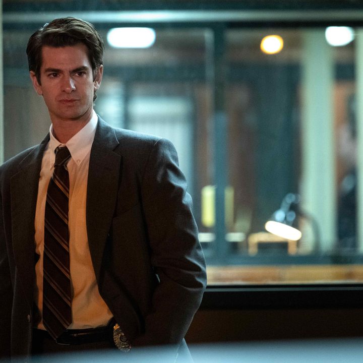 Andrew Garfield stands in front of a police station window in Under the Banner of Heaven.