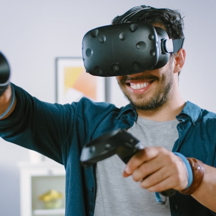 A man uses a VR headset while playing a game.