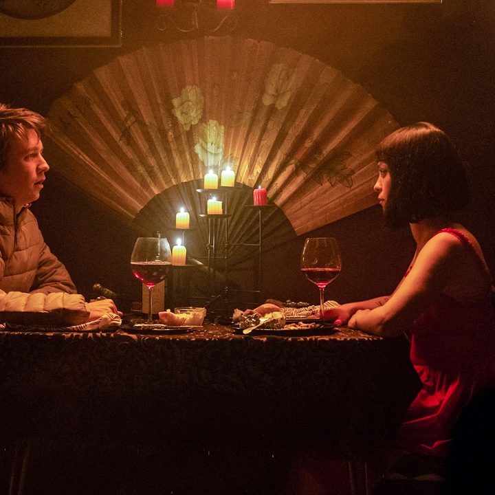 Thomas Mann and Rosa Salazar sitting at a table and talking in a scene from Chariot.