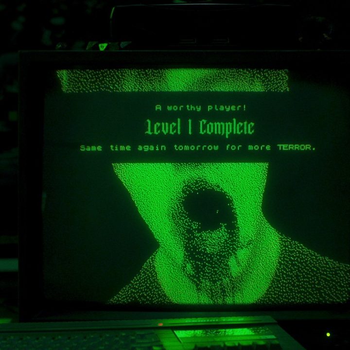 A computer screen showing gruesome ASCII art of a bloody face in a scene from Choose Or Die.