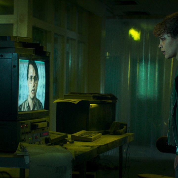 Iola evans stares at a TV screen in a scene from Choose Or Die.