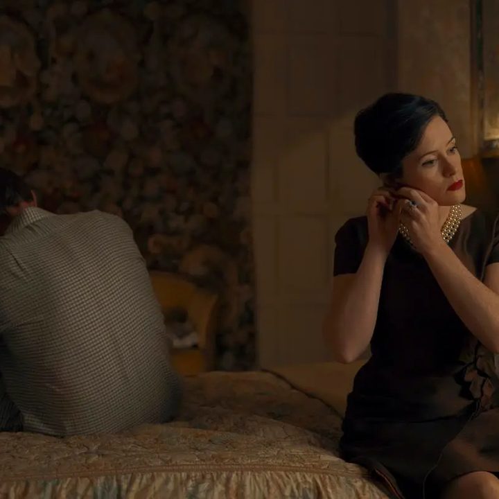 Claire Foy and Paul Bettany sit on opposite sides of the bed in A Very British Scandal.