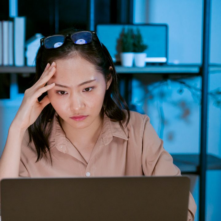 Woman working on laptop late at home.