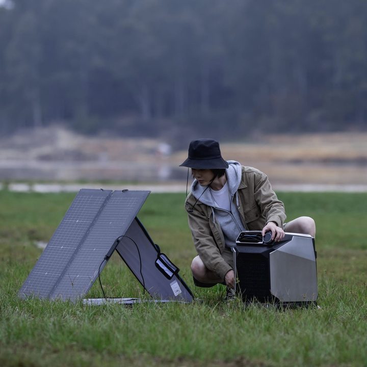 A camper uses an EcoFlow Wave with solar panel outdoors.