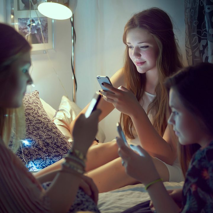 A group of teenage girls on their phones.