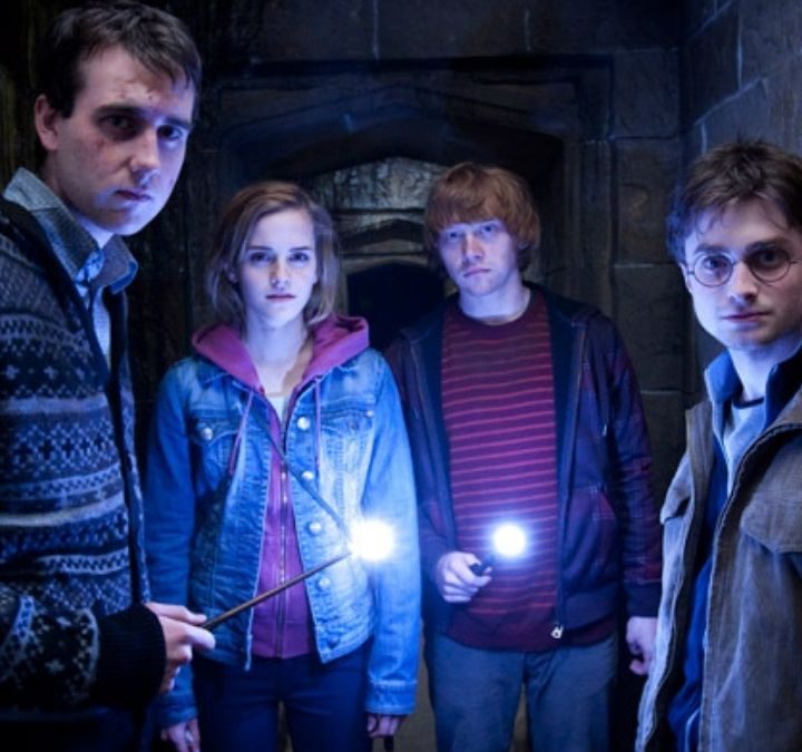 Neville, Hermione, Ron, and Harry inside a dark tunnel in HP and the Deathyl Hallows Part 2