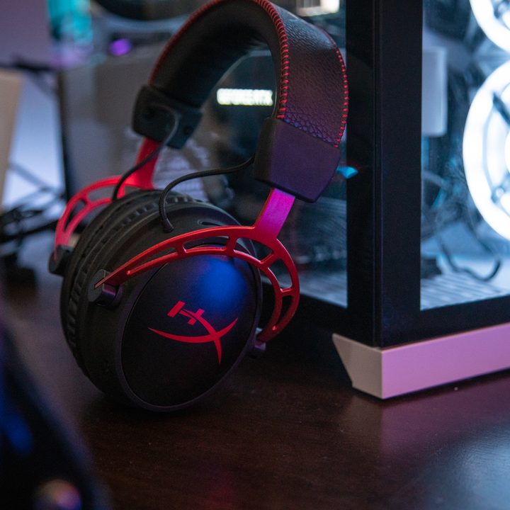 HyperX Cloud Alpha Wireless headset leaning against a gaming PC.