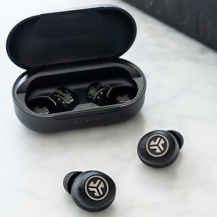 JLab JBuds Air Pro sitting beside their charging case.