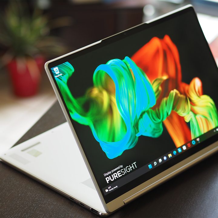 Lenovo Yoga 9i 14 Gen 7 laptop sits on a small desk in media mode.